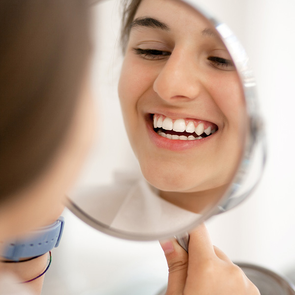 lady holding a mirror smiling